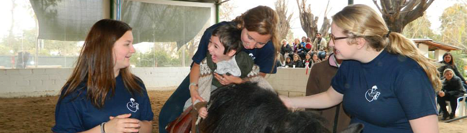 Alumno realizando monta doble con ayuda del equipo de la fundación
